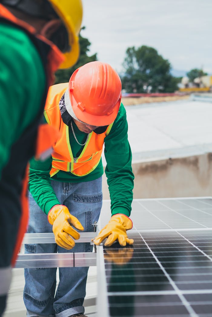 gallery-02 Worker in safety gear installing solar panels on a rooftop.